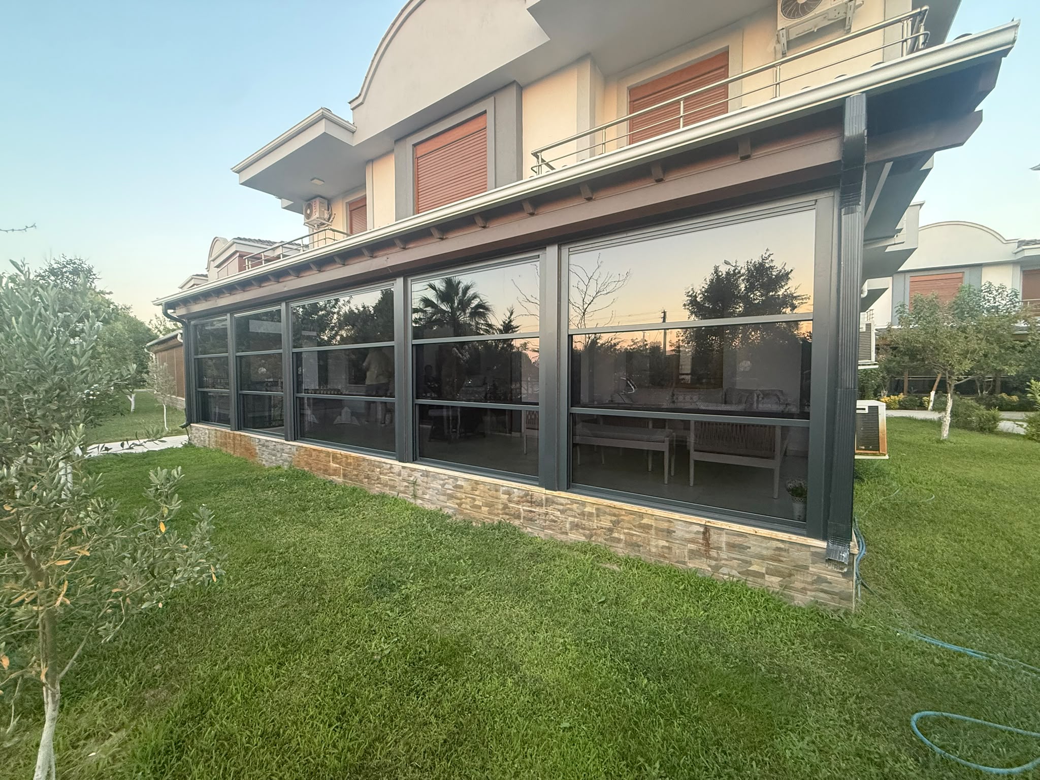 Ayvalık'ta cam balkon, zip perde ve korkuluk uygulanmış teras